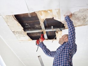 Worker fixing water damage on ceiling with a one-stop maintenance in idaho falls